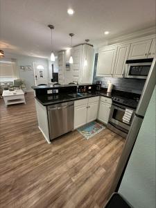 a kitchen with white cabinets and a wooden floor at Private condo just steps to St Pete Beach in St Pete Beach