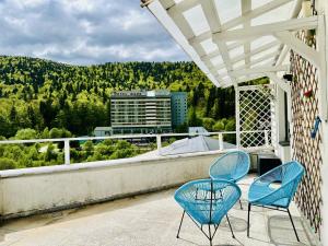 2 blaue Stühle auf einem Balkon mit Aussicht in der Unterkunft Sky is the limit in Sinaia