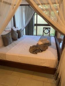 a large bed in a room with a canopy at Owen Studio in Diani Beach
