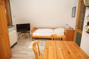 een kamer met een tafel, een bed en een televisie bij Ferienhaus mit viel Platz in Strandnaehe in Damp