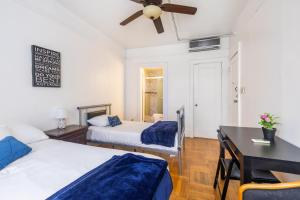 1 dormitorio con 2 camas, escritorio y mesa en KLO Guest House, en Brooklyn