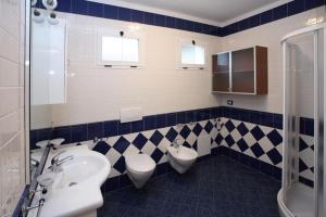 La salle de bains est pourvue de 2 lavabos et de 2 toilettes. dans l'établissement Villa Medea, à Rosolina Mare