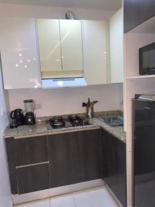 a kitchen with white cabinets and a stove top at HAS Shortlet in Lekki