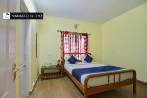 1 dormitorio con 1 cama con cortina roja en Super Collection O Kodai Mist Perumpallam - Managed by Company en Kodaikānāl