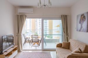 a living room with a couch and a table with chairs at Andreanius Caesar Resort & Spa Studio with Niche, Stunning Balcony View in Iskele