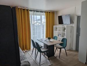 comedor con mesa, sillas y TV en Paris Access with Creteil Apartment en Créteil