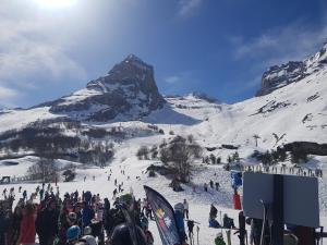 a crowd of people on a ski slope with a mountain at Appartement Val Soleil à 250 m des pistes in Gourette +7 photos