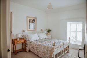 ein weißes Schlafzimmer mit einem Bett und einem Fenster in der Unterkunft Gatecroft House, Garrigill in Garrigill