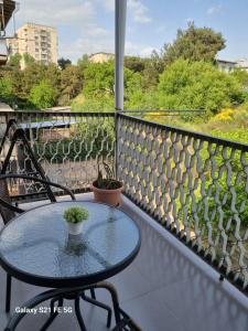 a table and chairs on a balcony with a view at Happy 1 in Tbilisi City