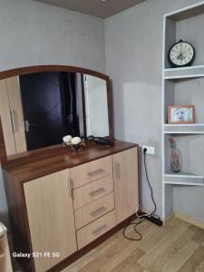 komodę z lustrem i zegarem w pokoju w obiekcie Happy 1 w mieście Tbilisi City