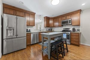 a kitchen with stainless steel appliances and wooden cabinets at Cozy Hub near Louisville's Attractions w Office in Louisville