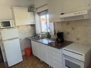 a kitchen with a white refrigerator and a sink at Appart FAFE in Meidelo
