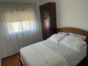 a bedroom with a bed with a wooden headboard and a window at Appart FAFE in Meidelo