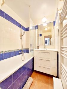 uma casa de banho com uma banheira, um chuveiro e um lavatório. em Le DRAMONT Appartement vue panoramique MER LAC FORET em Saint-Raphaël