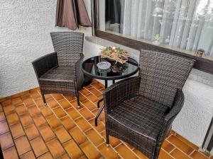 two chairs and a table on a balcony with a tableablish at Hotel Waldsee in Waldachtal