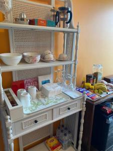 un estante blanco con comida y otros artículos. en French Boutique Loft Apartment @Chapmans+breakfast, en Moss Vale