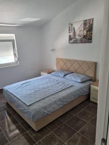 a bedroom with a bed with a blue comforter at Demir Apartmani in Donji Štoj