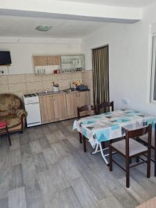 a kitchen with a table and chairs in a room at Demir Apartmani in Donji Štoj