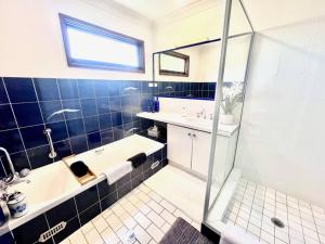 y baño con bañera, lavamanos y ducha. en French Boutique Loft Apartment @Chapmans+breakfast, en Moss Vale