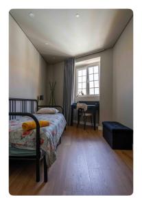 een slaapkamer met een bed, een bureau en een raam bij Quebra Costas House in Coimbra