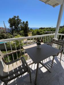 un tavolo e sedie su un balcone con vista sull'oceano di Golden Evelyn ad Agia Paraskevi