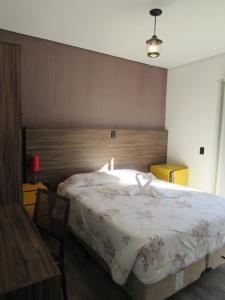 um quarto com uma cama grande e uma cabeceira em madeira em Golden Forest Pousada em Campos de Jordão