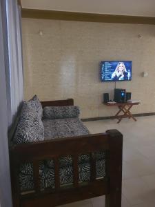 uma sala de estar com uma cama e uma televisão de ecrã plano em Picho two bedroom apartment em Melinde