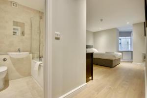 a bathroom with a shower and a bedroom with a bed at Orange Grove Hotel & Gardens in Southampton +100 photos