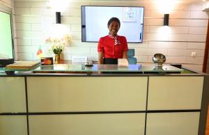 a woman standing behind a counter in a room at ADAMAOUA GRAND HOTEL AKWA in Douala