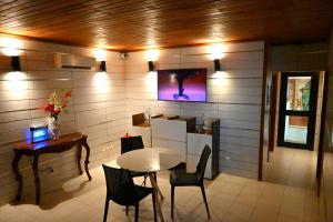 - une salle à manger avec une table, des chaises et une télévision dans l'établissement ADAMAOUA GRAND HOTEL AKWA, à Douala