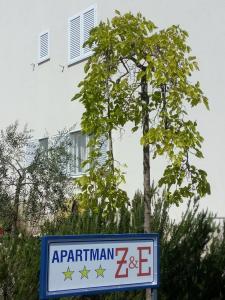 una señal frente a un árbol y un edificio en Apartment Z&E, en Trogir