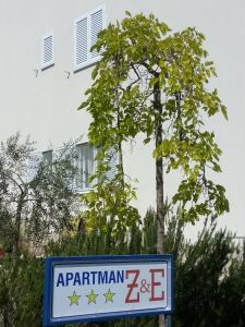 a sign in front of a tree and a building at Apartment Z&E in Trogir