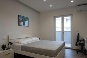 een slaapkamer met een bed, een bureau en een raam bij ANSIRO Rooms Home Business in Scisciano