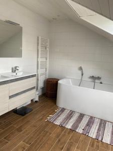 un bagno bianco con vasca e lavandino di Le Loft brestois a Brest