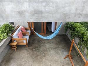 a hammock in a room with plants at Hermanos Perdidos Surf in Las Tunas