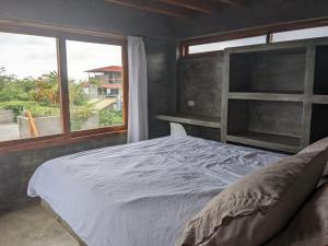 a bedroom with a large bed and a window at Hermanos Perdidos Surf in Las Tunas