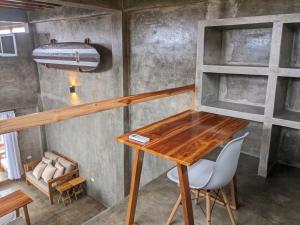 a wooden table and chairs in a room at Hermanos Perdidos Surf in Las Tunas