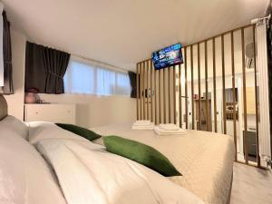 een slaapkamer met een bed en een tv aan de muur bij SaliS28 MM3 Affori Centro in Milaan