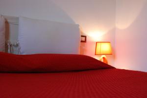 een rood bed met een rode sprei en een lamp bij Tanca is Torus in Teulada