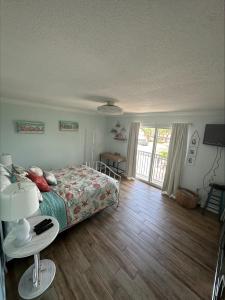 a bedroom with a bed and a wooden floor at Private condo just steps to St Pete Beach in St Pete Beach