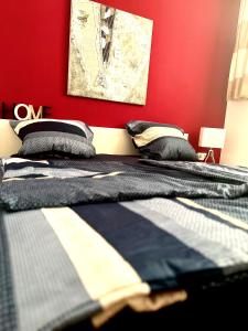 2 letti in una camera da letto con parete rossa di Solymar Premium Apartment a San Bartolomé