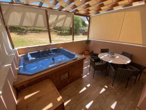 a hot tub in a porch with a table and chairs at Villa Nickolas in Paleo Tsifliki