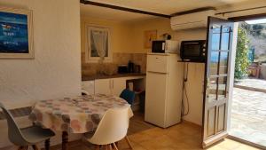 uma pequena cozinha com uma mesa e um frigorífico em LOCATION CORSE em Canari