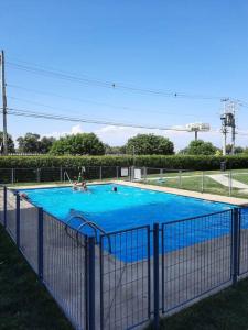 a large blue swimming pool with two people in it at Departamento SUR, tu hogar, tu espacio in Santiago