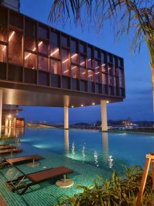 a view of a building with a swimming pool at night at Bali Residence Impian Raudah in Melaka