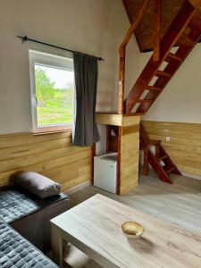 ein Wohnzimmer mit einer Treppe, einem Sofa und einem Tisch in der Unterkunft Rural Resort Tron in Plužine
