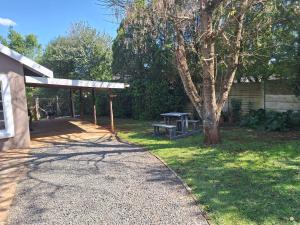 a park with a picnic table and a tree at Siesta Cottage in Howick