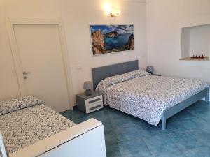una camera con due letti e un comodino di Casa Acqua Marina Le Forna a Ponza