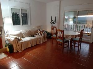 a living room with a couch and a table and chairs at Habitación y Baño Privado, Tranquilidad y Naturaleza. in Barcelona