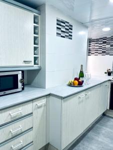 een witte keuken met een fruitschaal en een magnetron bij Cardenales in Barcelona
